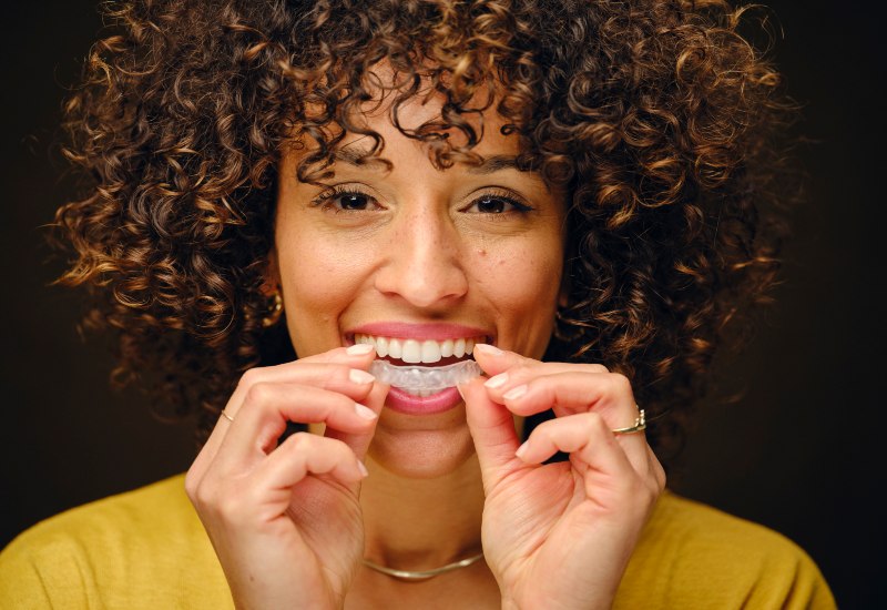 Woman using Invisalign Clear Aligners in Mokena and New Lenox, IL for a straighter, confident smile